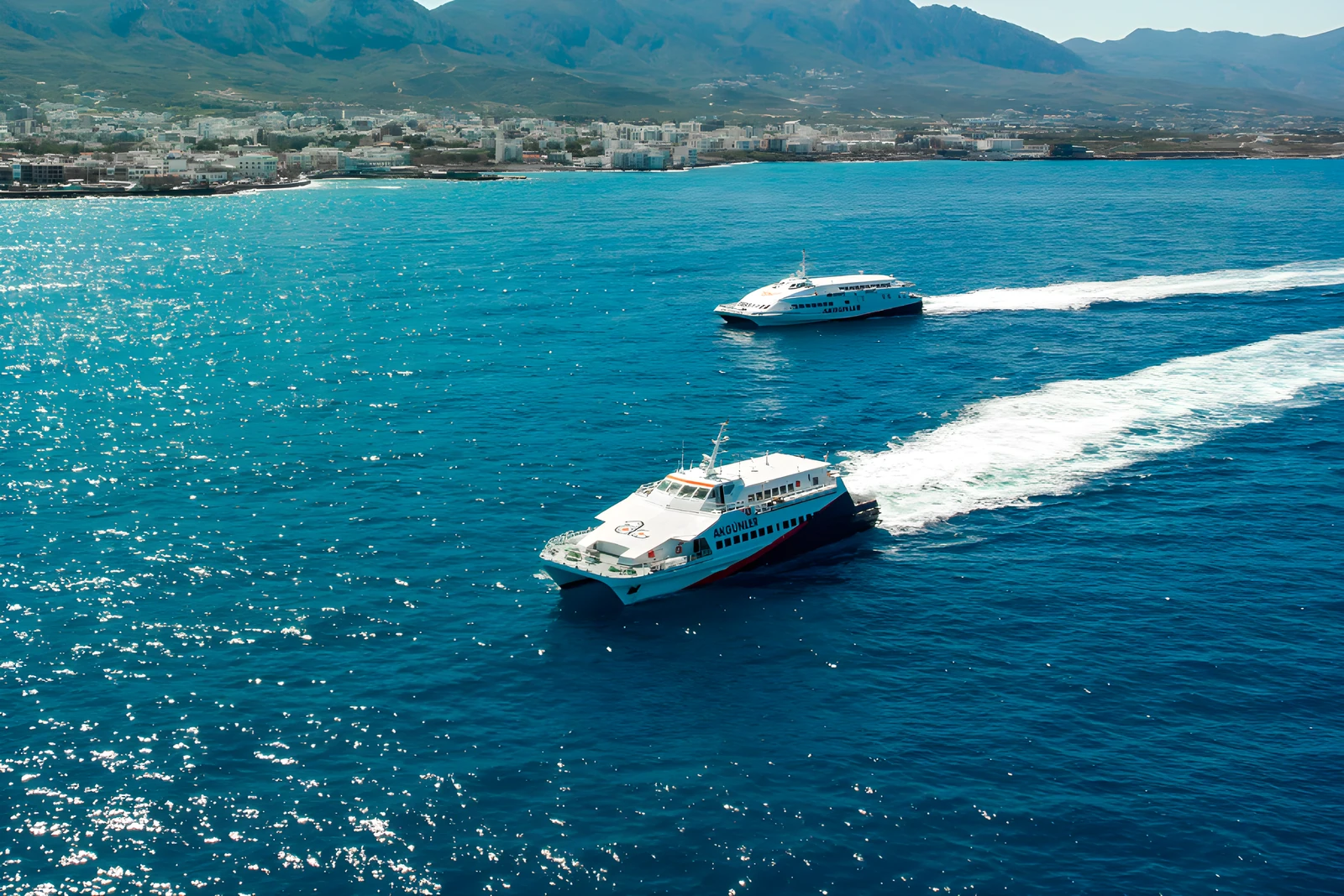 İki deniz otobüsü Girne açıklarında köpük izi bırakarak seyrediyor